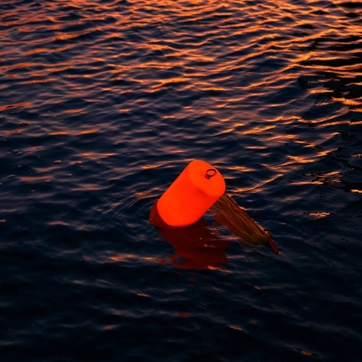 Glow Buoy LED float glowing red on the water at night