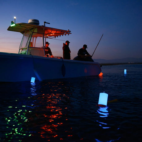 Glow Buoy LED floats glowing blue beside a boat at dusk