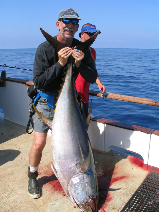 Mark Smith with a big yellowfin tuna on the deck of a long-range boat, 2005